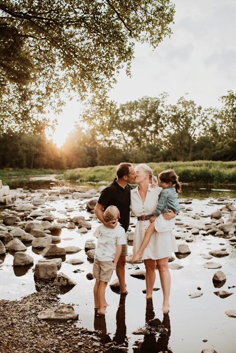 Parents embracing while kids play by creek in Oak Brook Illionis